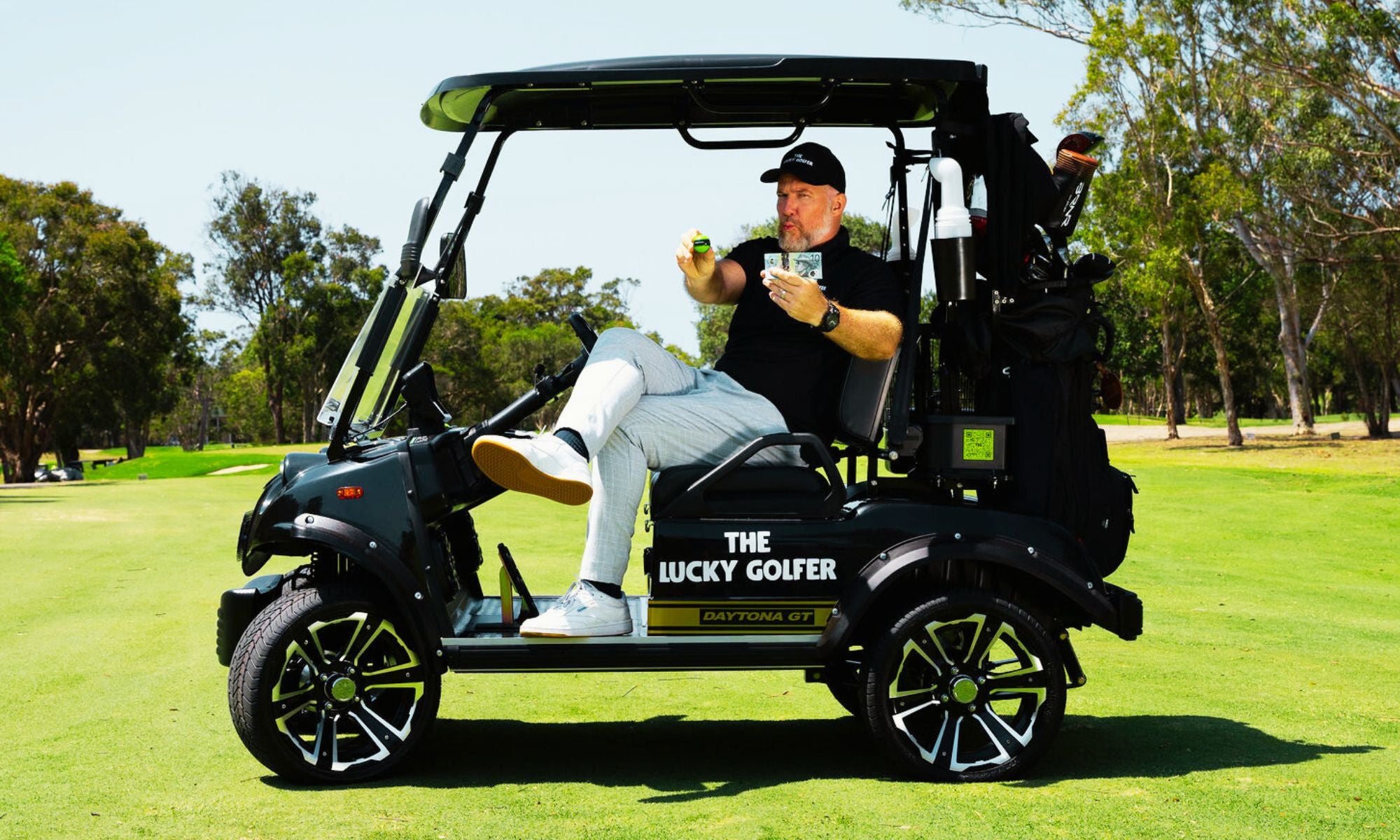 The Lucky Golfer man in golf buggy holding golf ball to win prizes